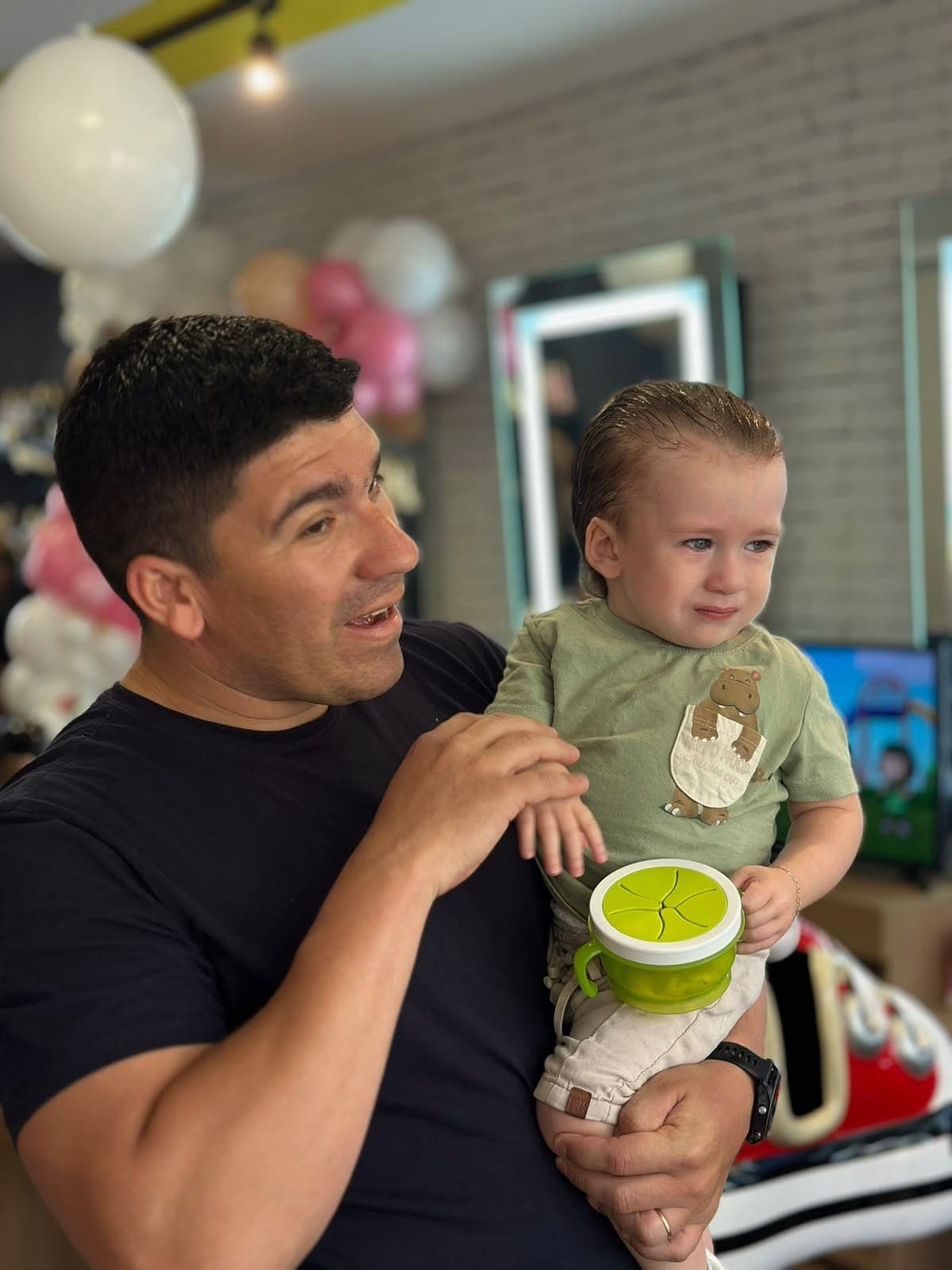 Pai com o bebê após o primeiro corte de cabelo