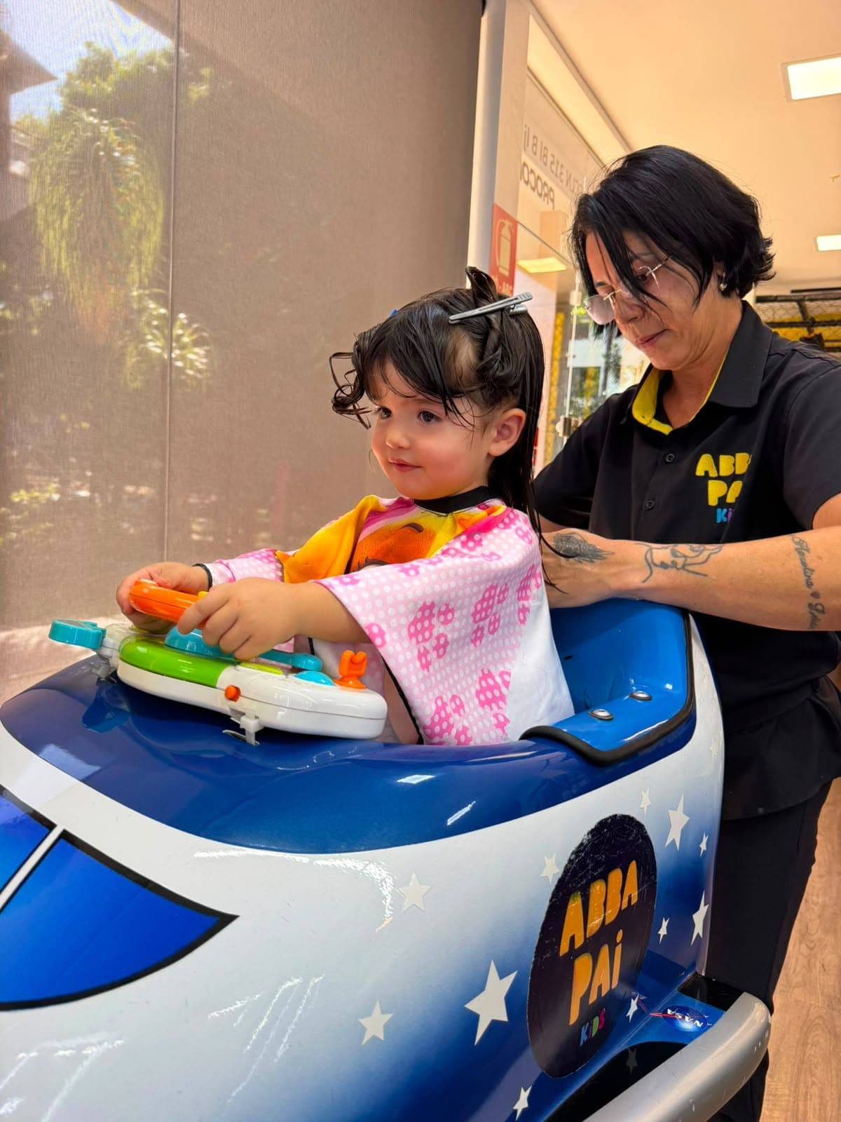 Criança sorrindo durante o corte de cabelo na Abba Pai Kids